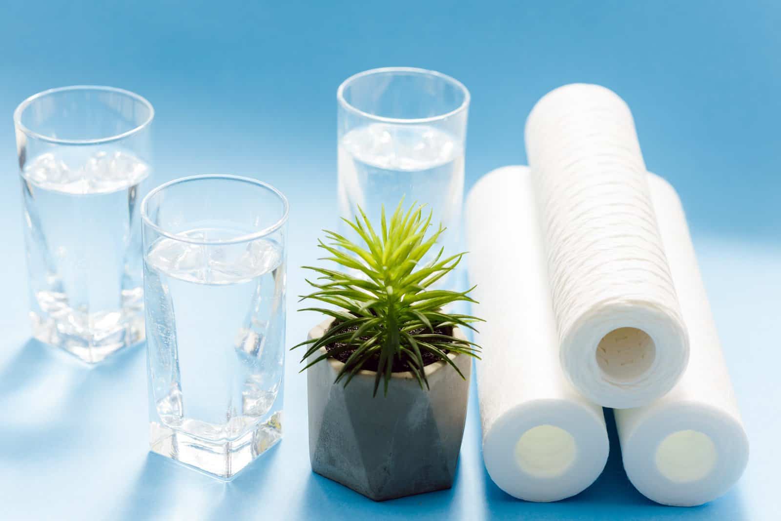 Filtros de água. Cartuchos de carbono e óculos em um fundo azul. Sistema de filtragem doméstica.