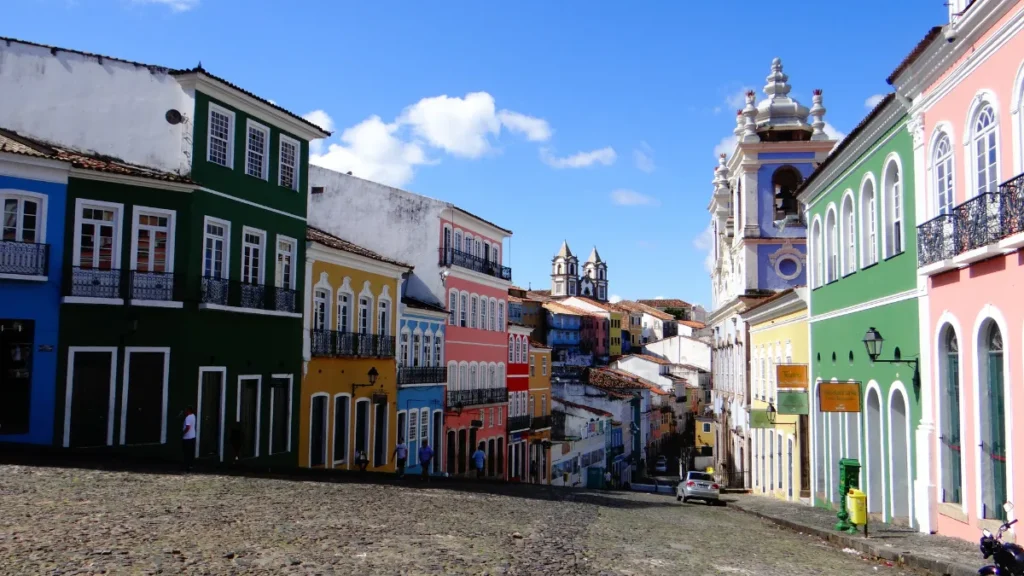 Ruas coloridas do Pelourinho em Salvador, com baianas em trajes tradicionais.