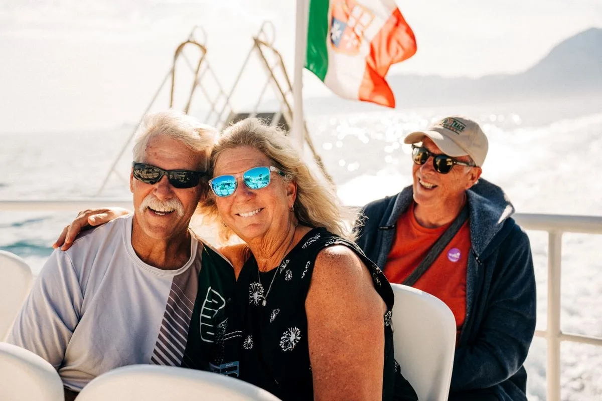 Três pessoas sorrindo em um passeio de barco