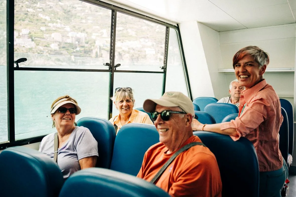 pessoas sorrindo enquanto estão em um passeio de barco